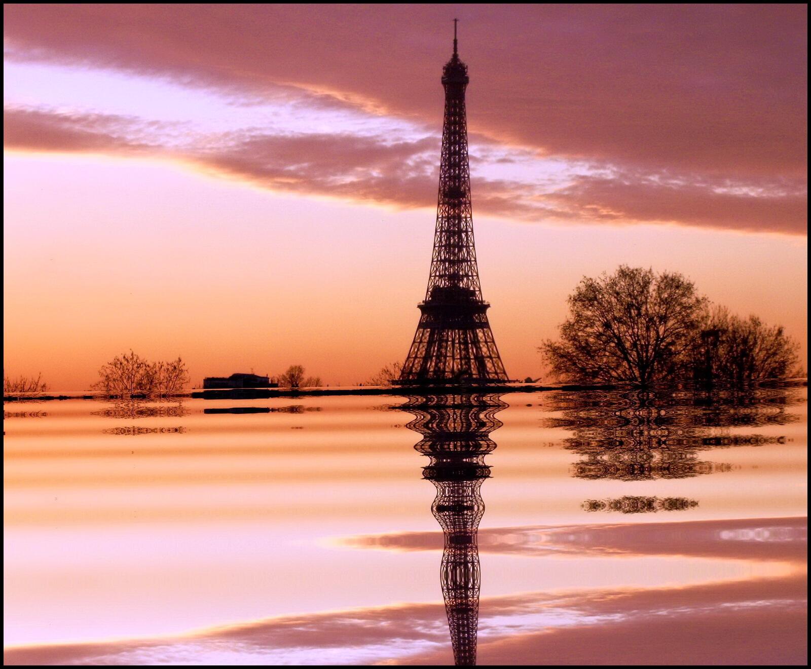 Бесплатное фото Эйфелева башня отражается в воде на закате