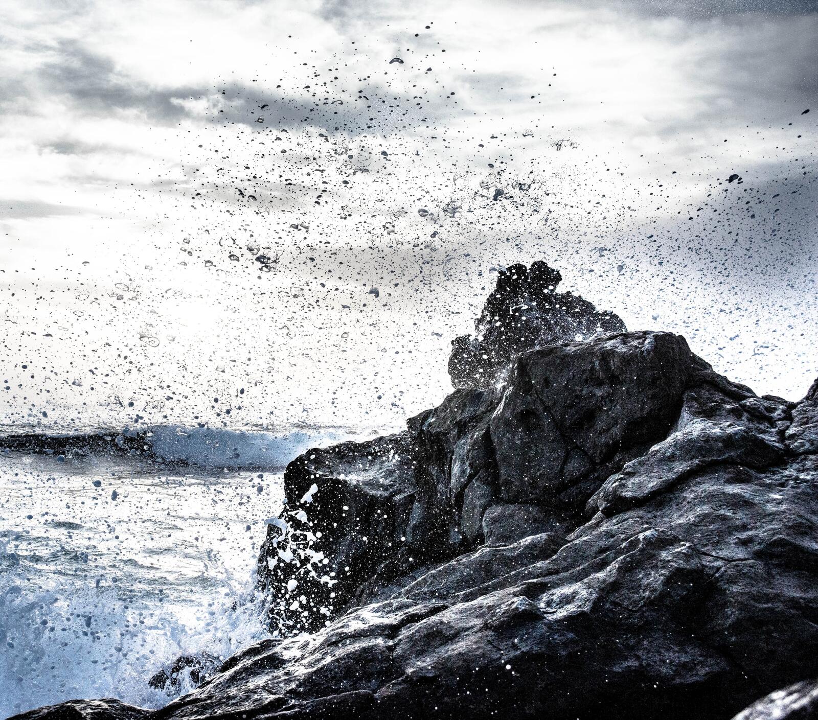 Бесплатное фото Капли от бьющегося моря о скалы