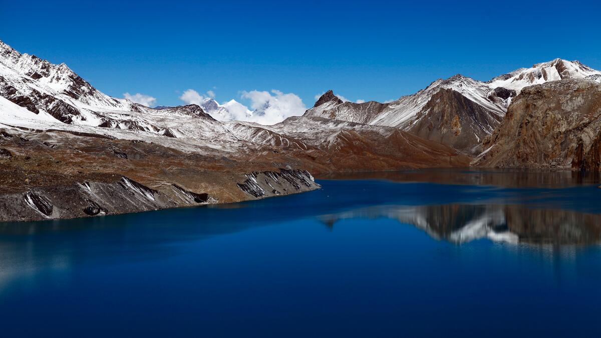 Озеро среди гор с запорошенными вершинами