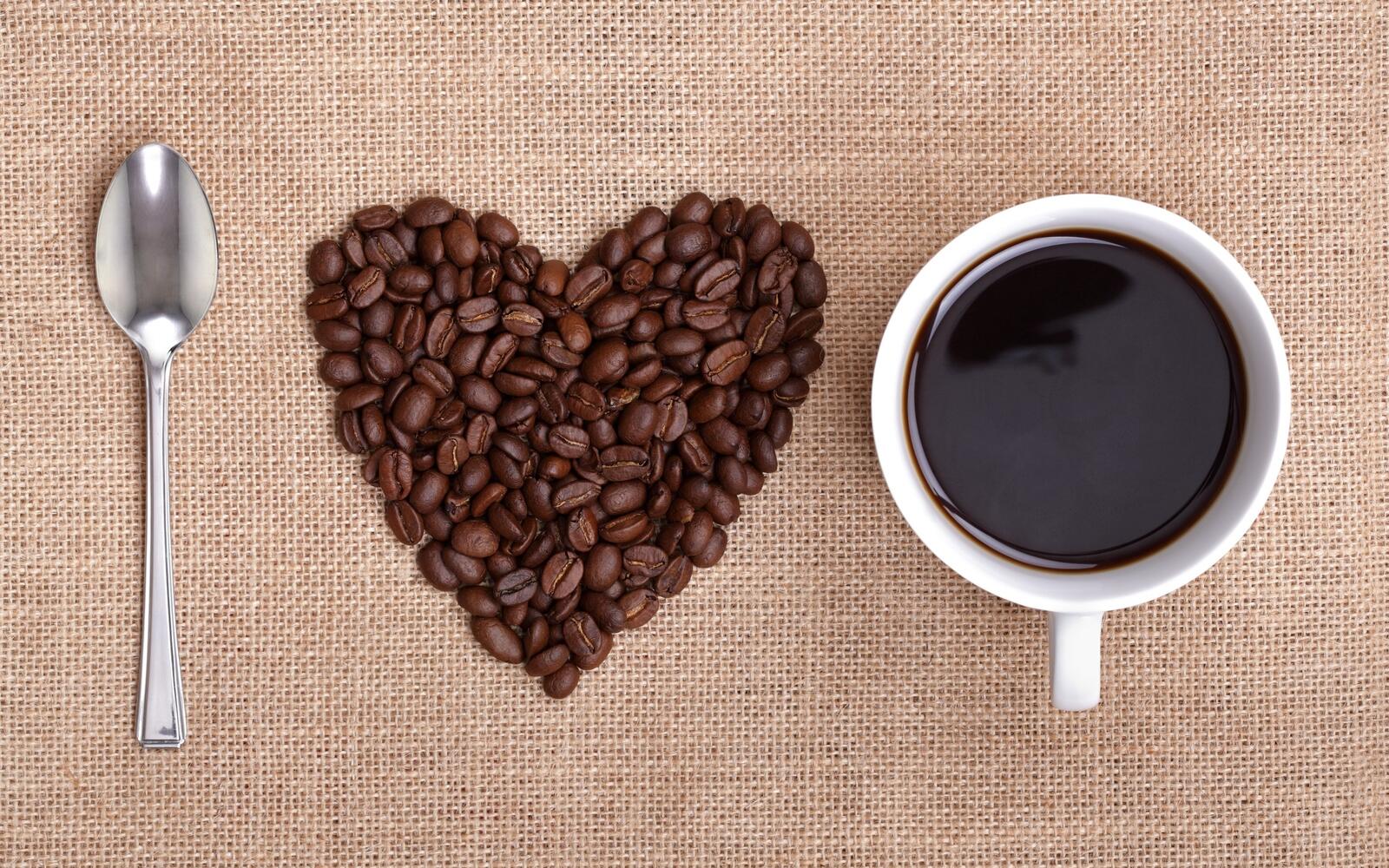 Бесплатное фото Чашка кофе с зернами кофе в виде сердечка