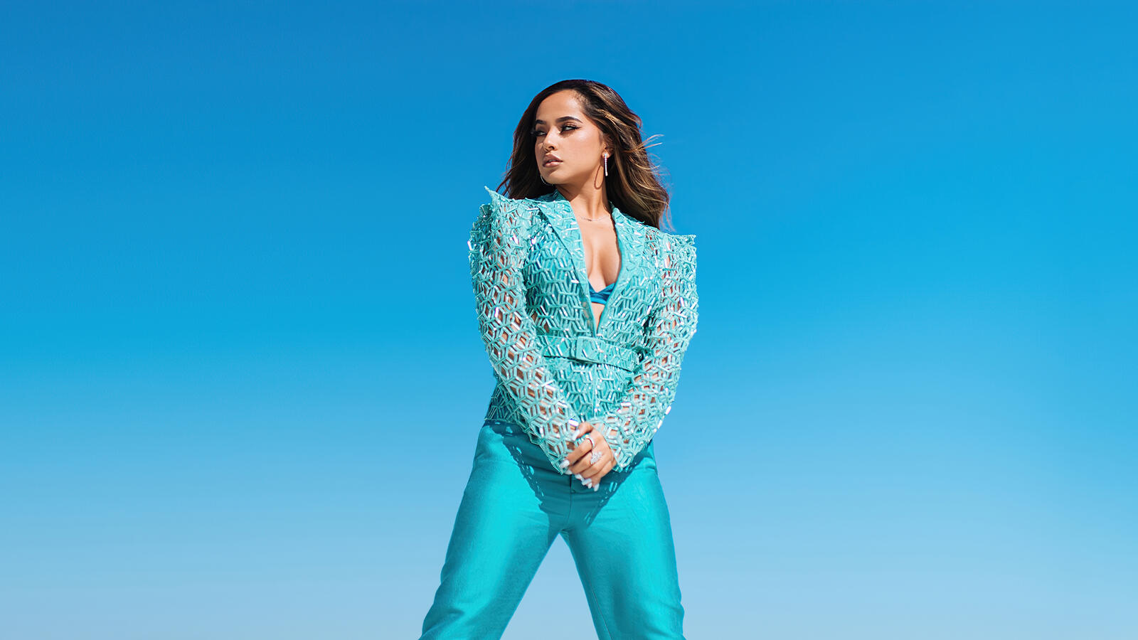 Free photo Becky G on a blue background in a blue suit