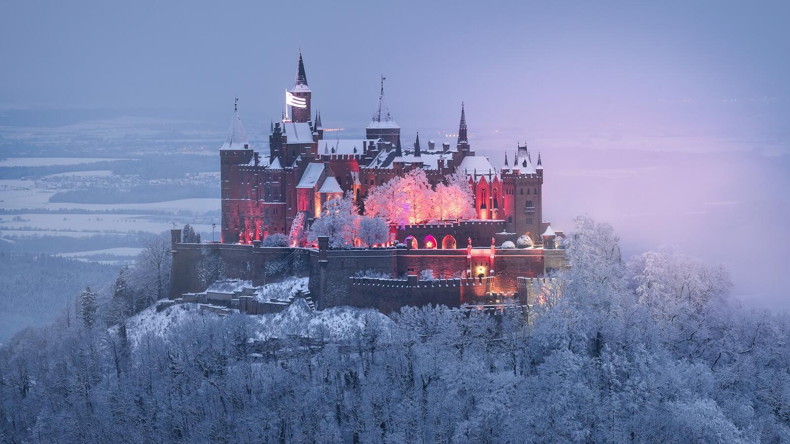 Бесплатное фото Большой замок в Германии на вершине горы в зимнем лесу