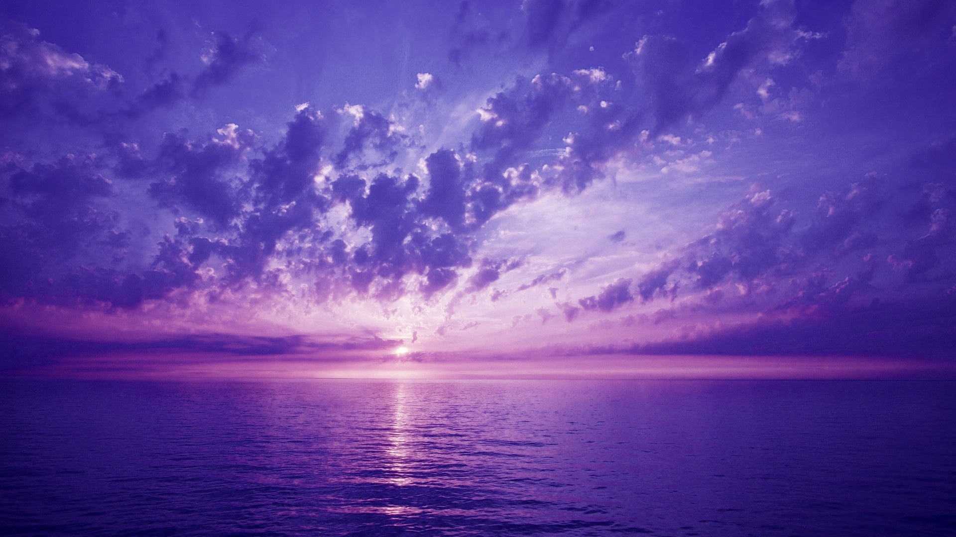 Фиолетовый закат на небе с облаками на море