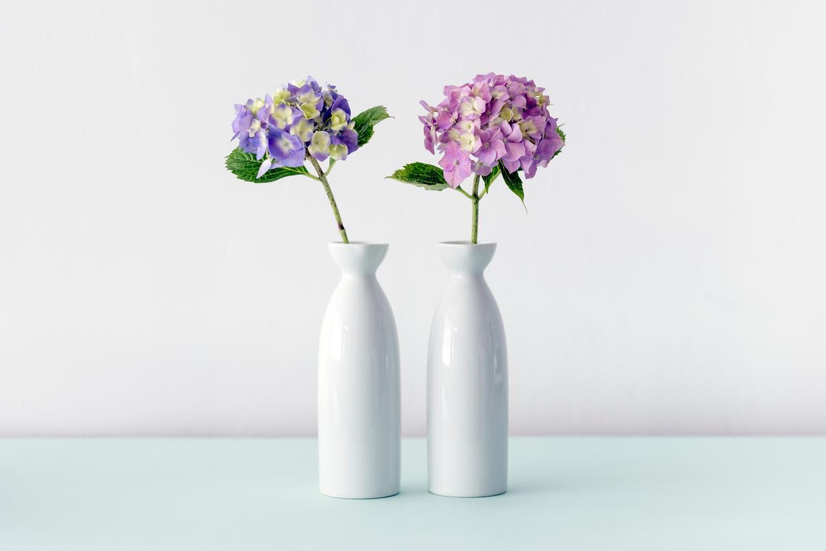 Two white vases with purple flowers