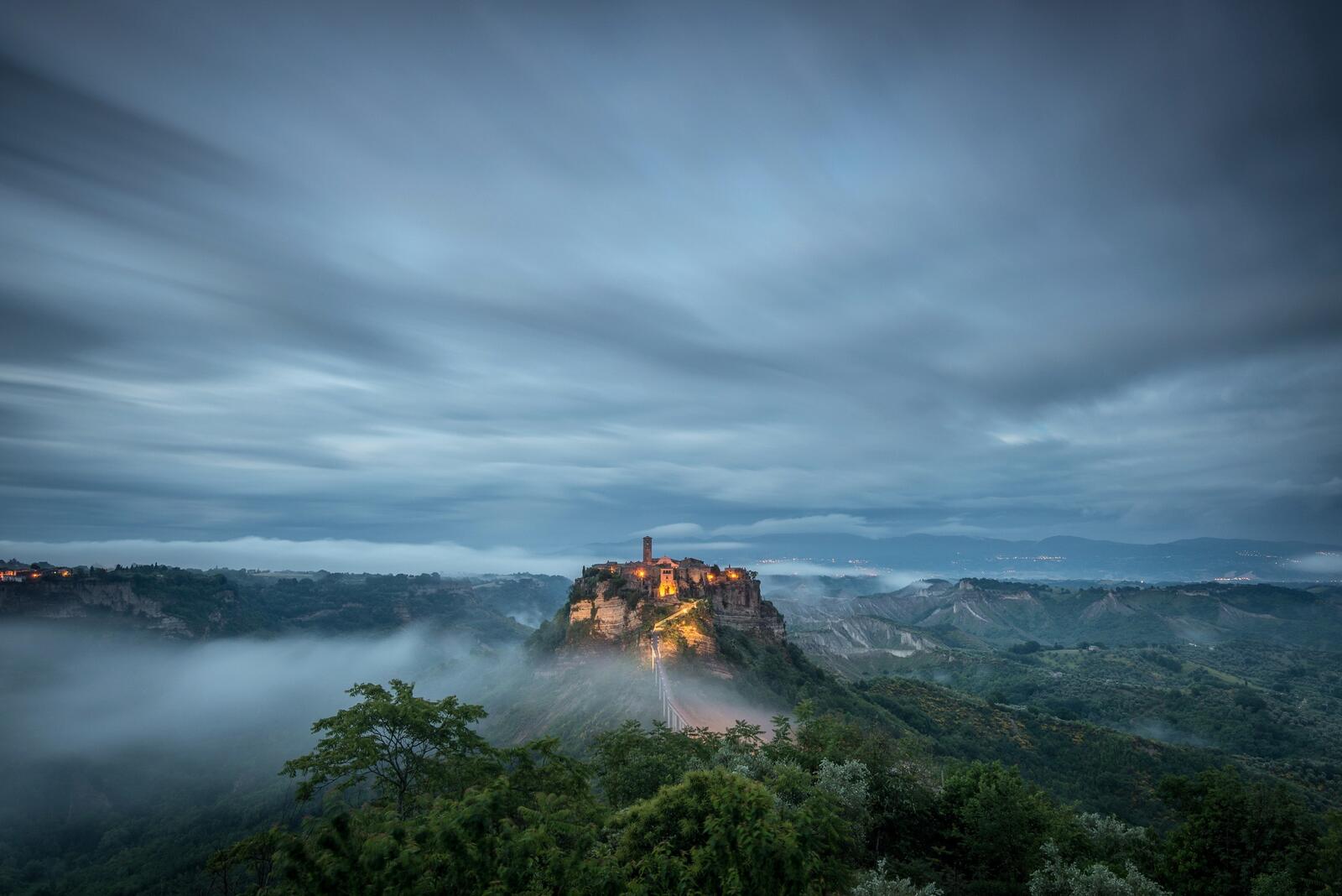 Free photo A castle in the mist on a mountain top in the middle of a dense forest