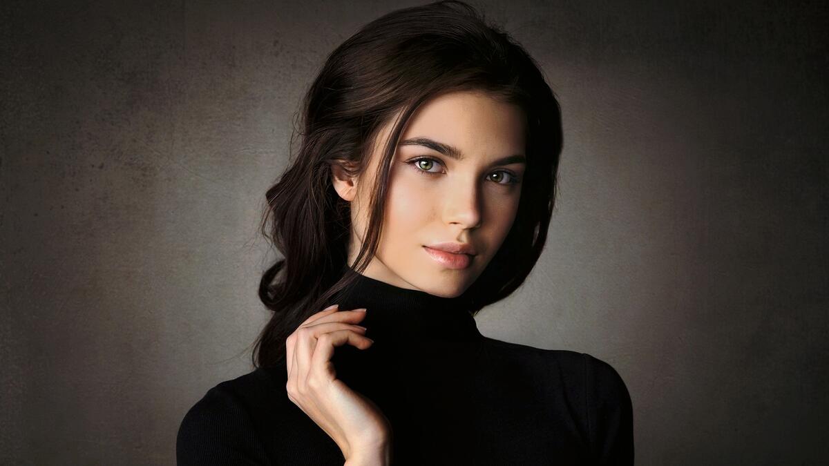 Portrait of a girl in a black sweater on a gray background