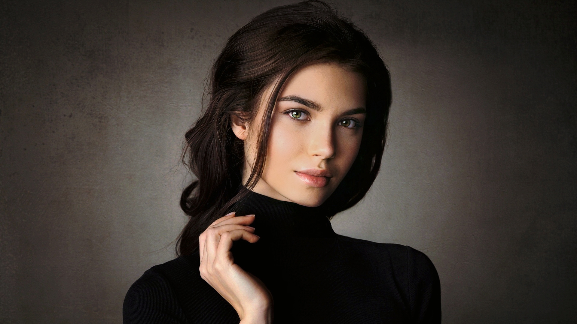 Портрет девушки в черном свитере на сером фоне