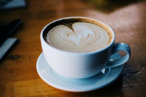 A cup of coffee with foam in the shape of a heart