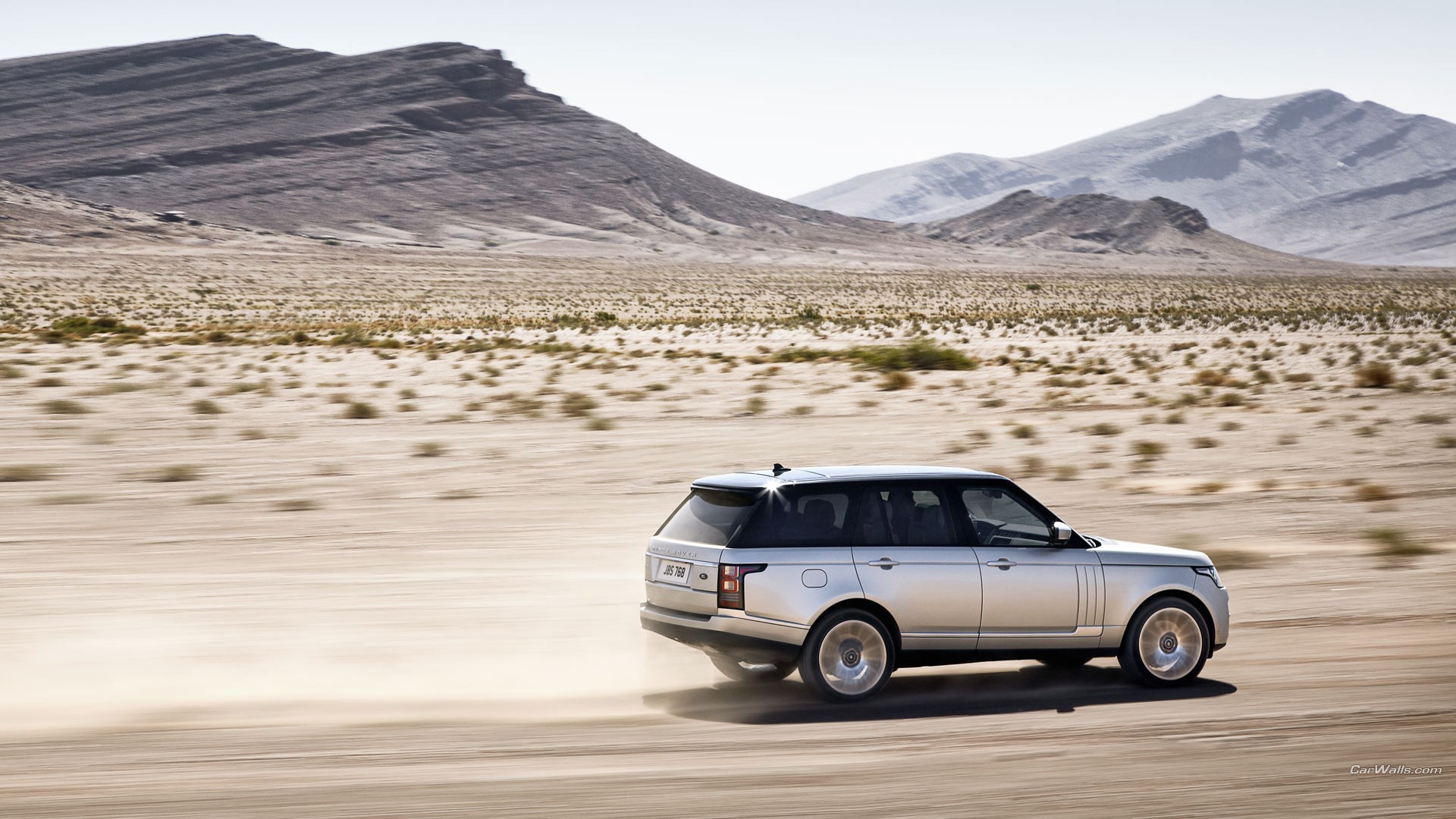 Range Rover едет по пыли на большой скорости