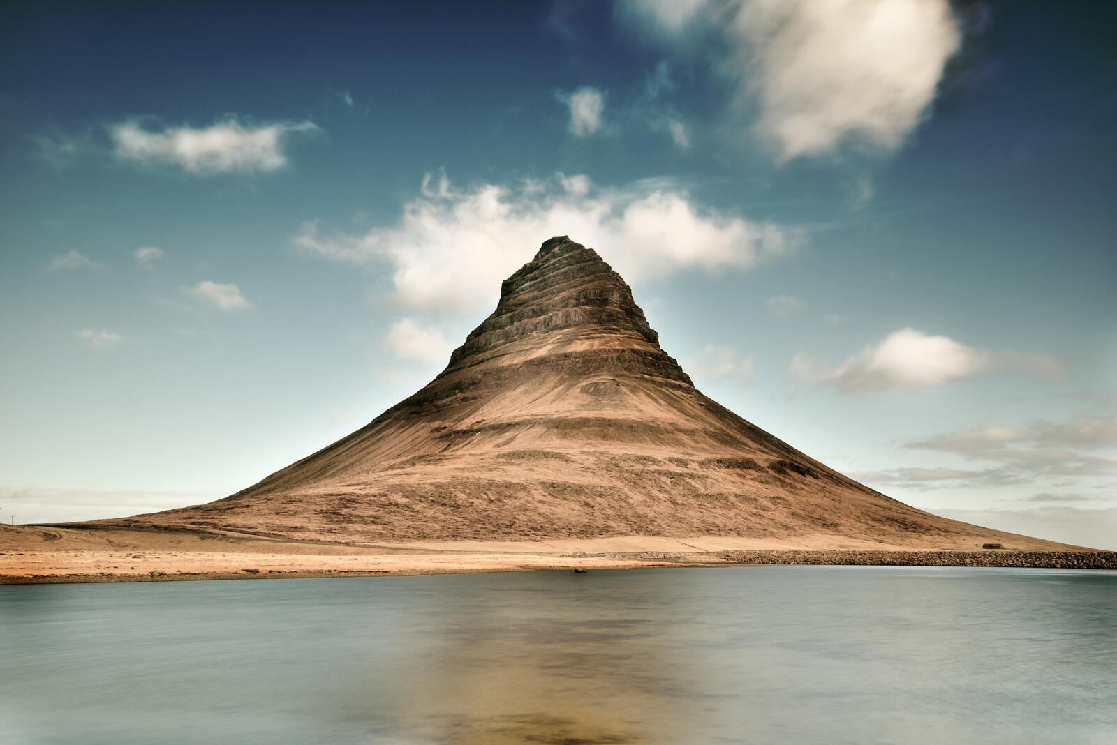 免费照片湖边有一座奇怪的螺旋山。