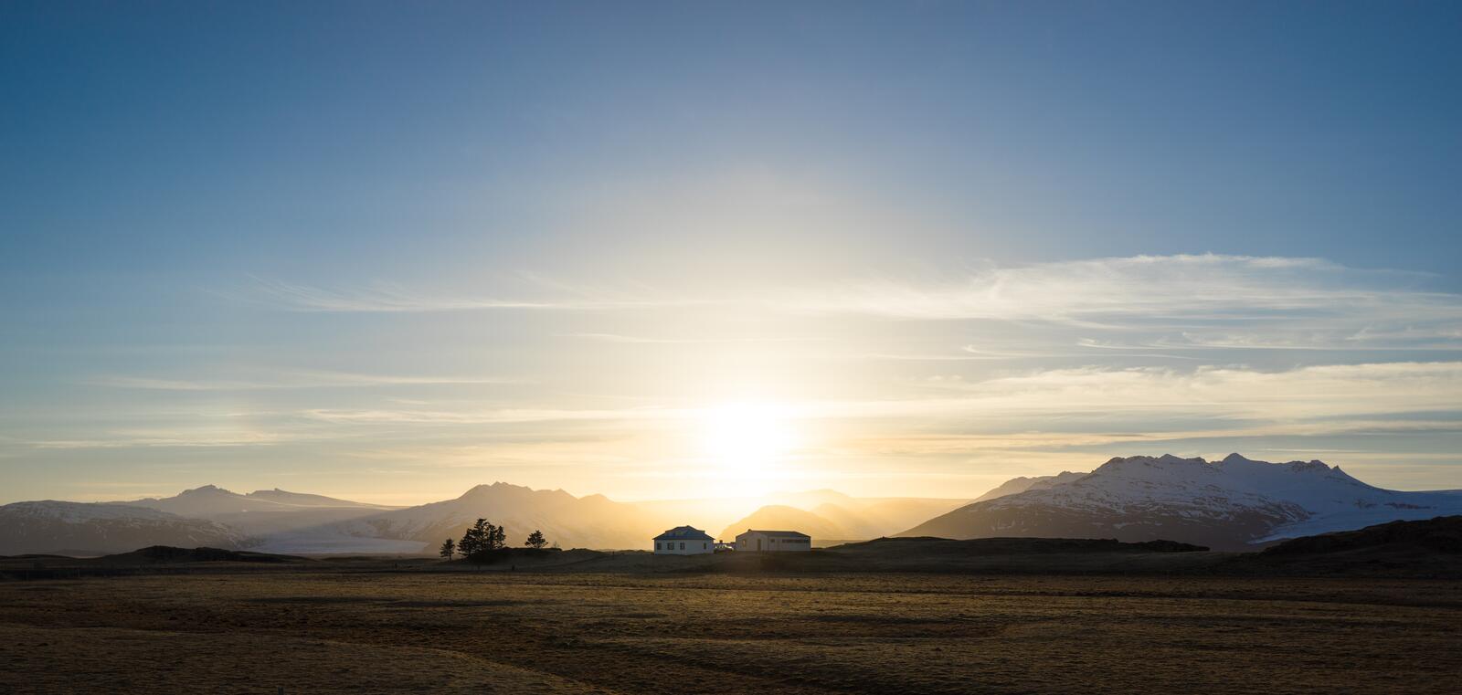 Бесплатное фото Загородный домик в поле возле гор на восходе солнца