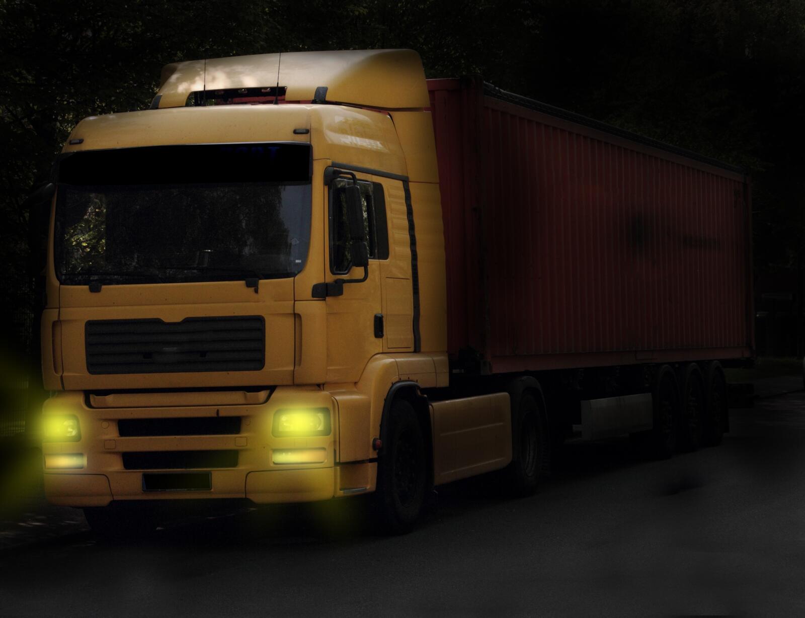 Free photo Yellow Manx truck with lights on in the dark.