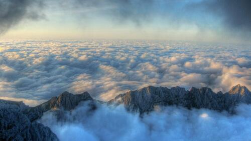 Вершины гор виднеются через густые облака
