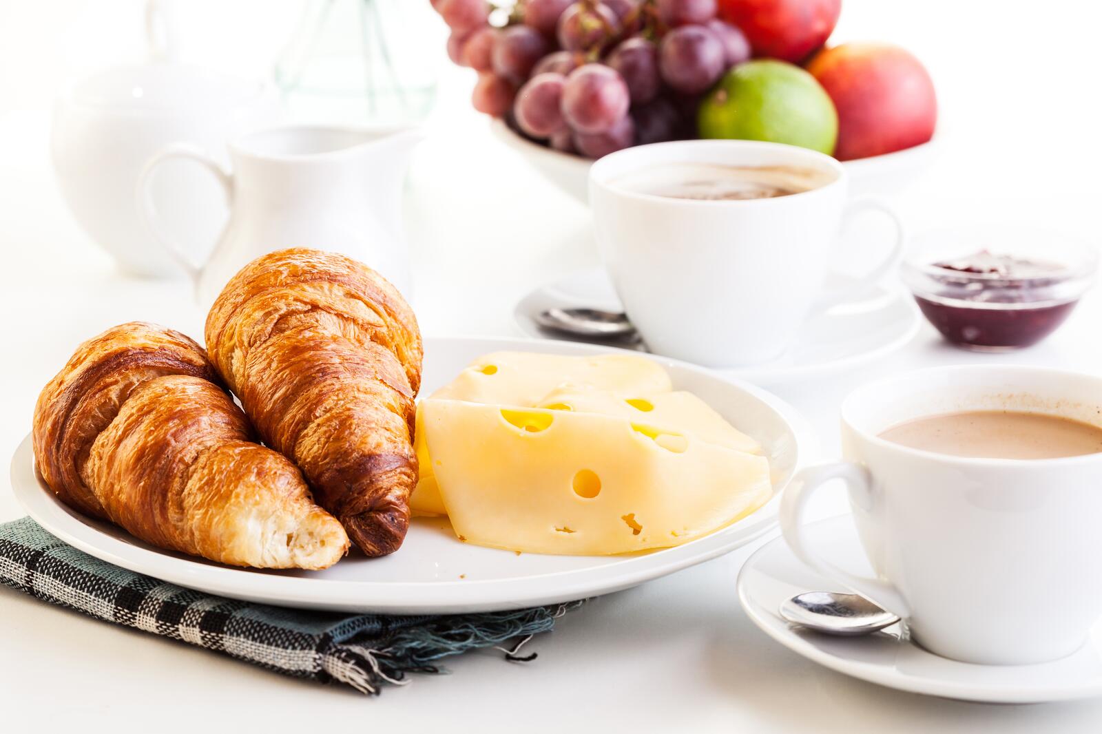 Бесплатное фото Круассан в тарелке с сыром и кофе