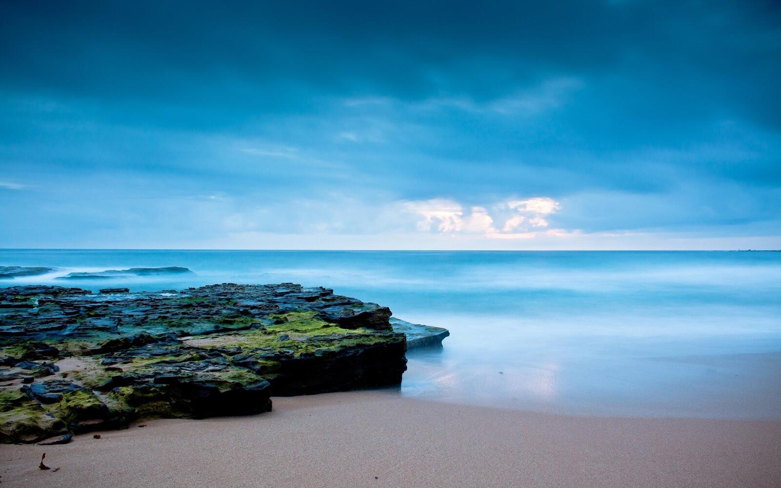 Бесплатное фото Большой скалистый камень на морском пляжу