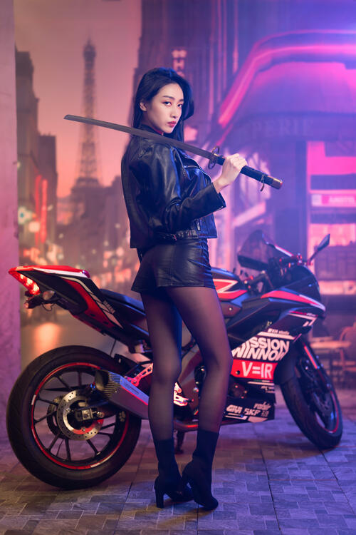 Девушка азиатской внешности рядом со спортивным мотоциклом и катаной