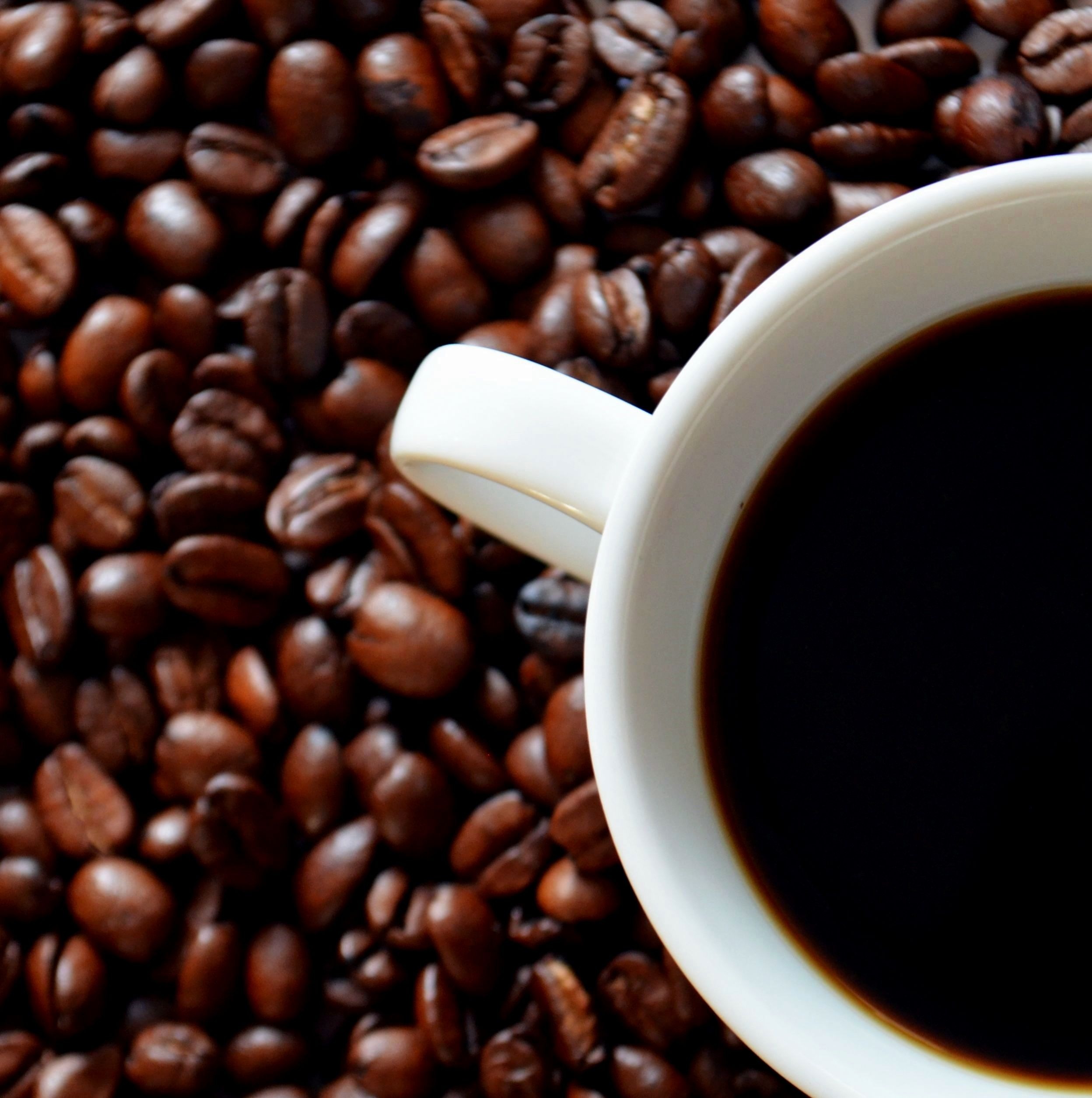 Зерна кофе с чашкой кофе