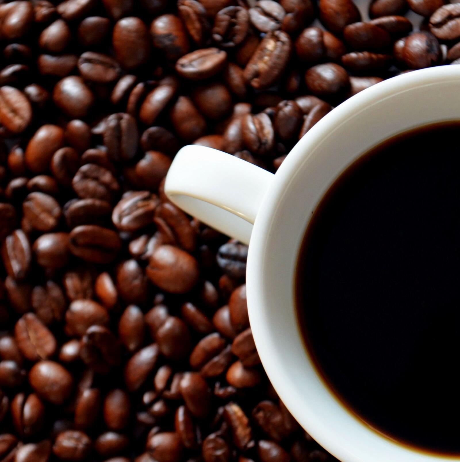 Бесплатное фото Зерна кофе с чашкой кофе