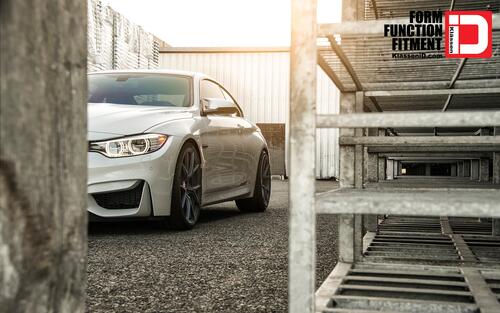 A white BMW M4 peeks out from around the corner.