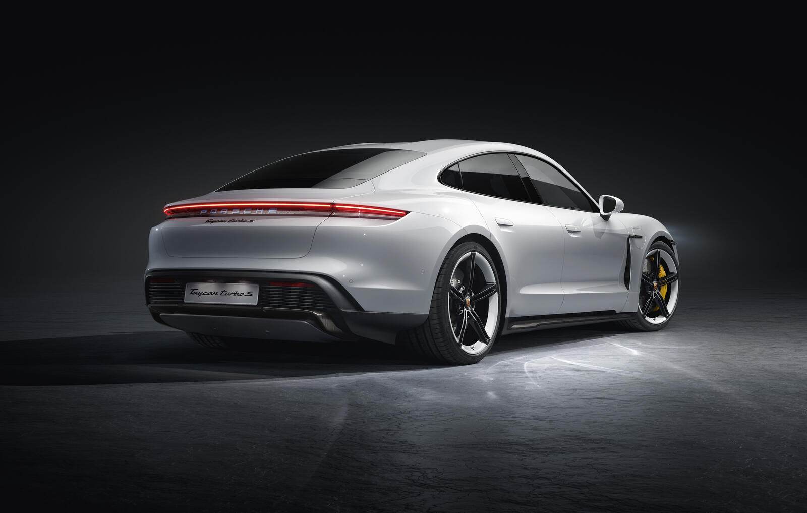 Free photo Porsche Taycan Turbo S in gray on a black background