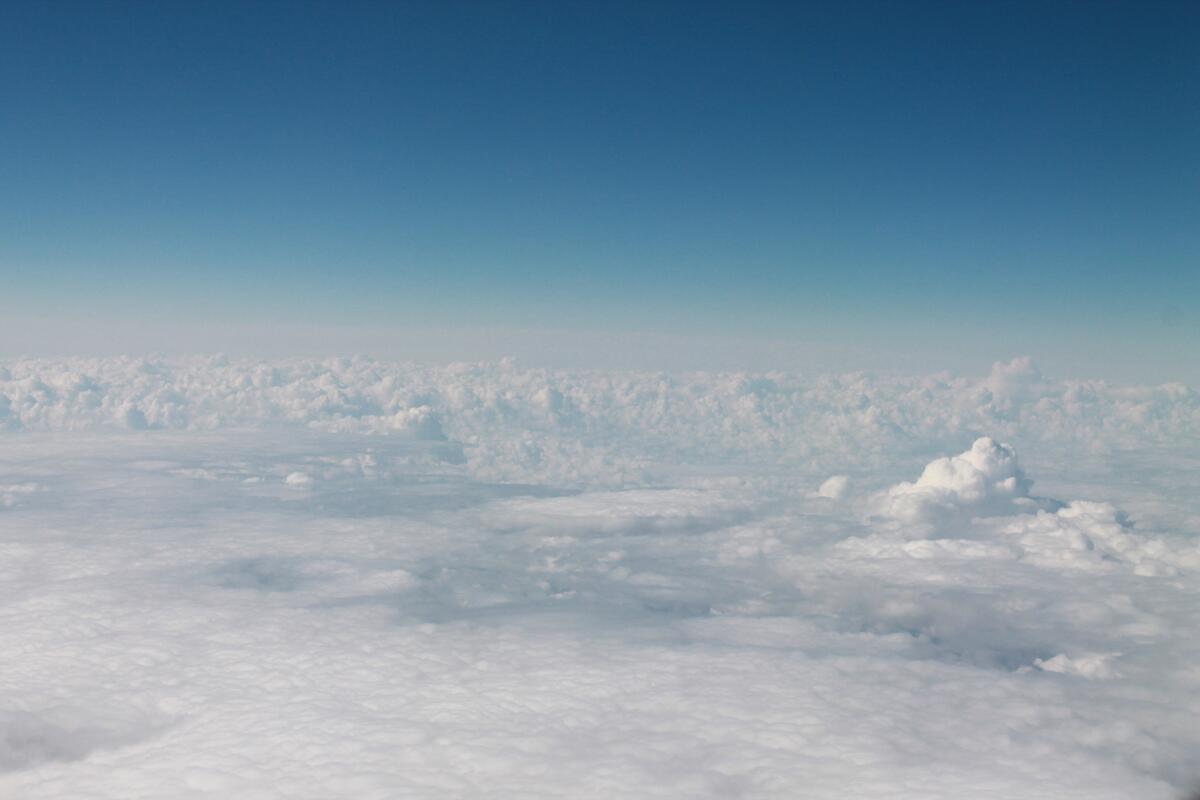 Flying in an airplane over piles of clouds