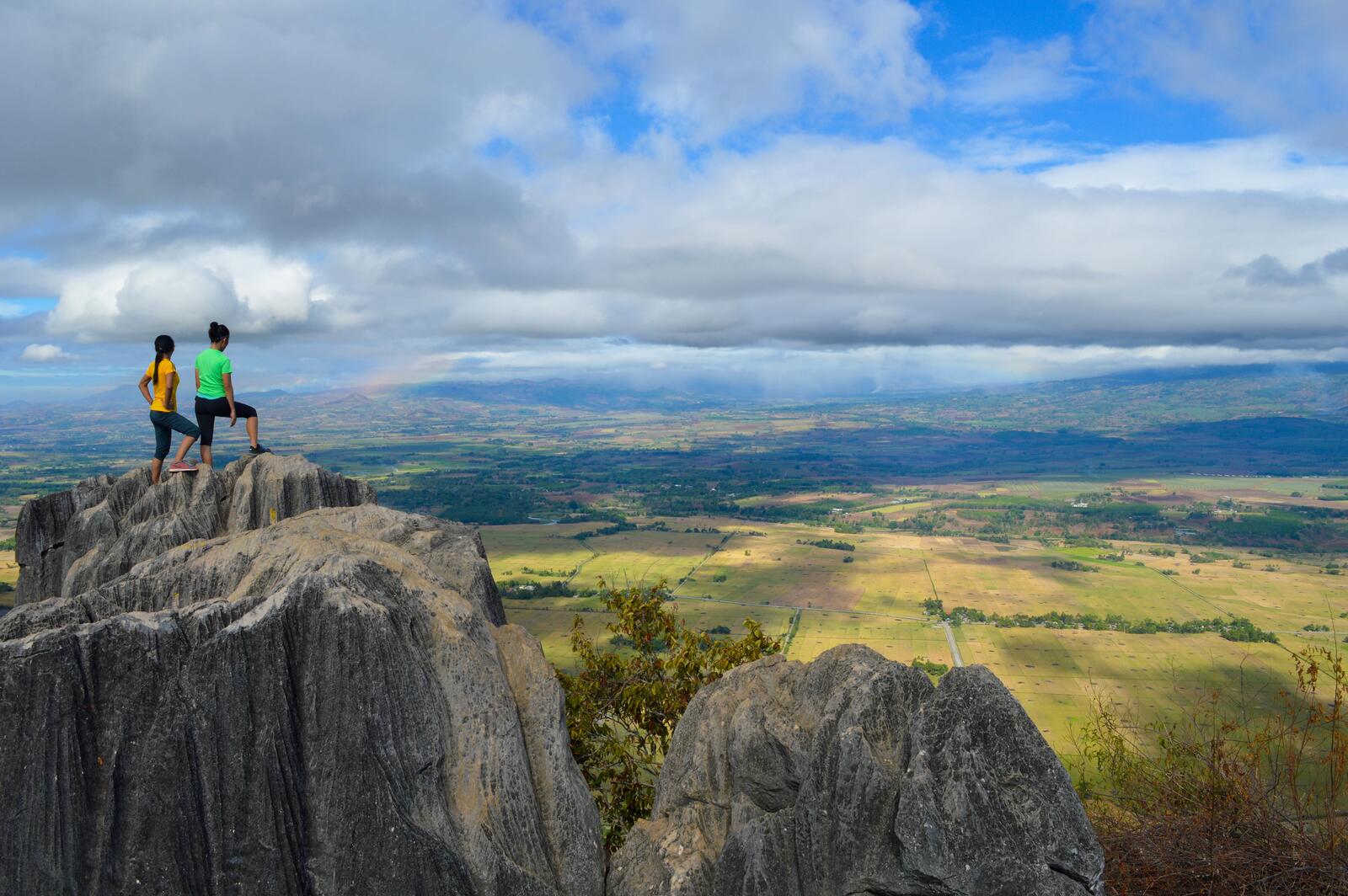 Бесплатное фото Люди на вершине скалы любуются просторами