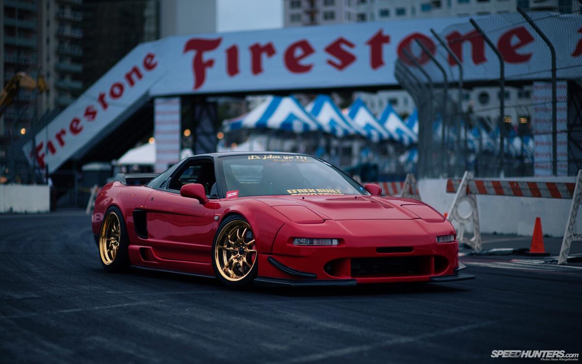 A red Honda NSX on gold rims.