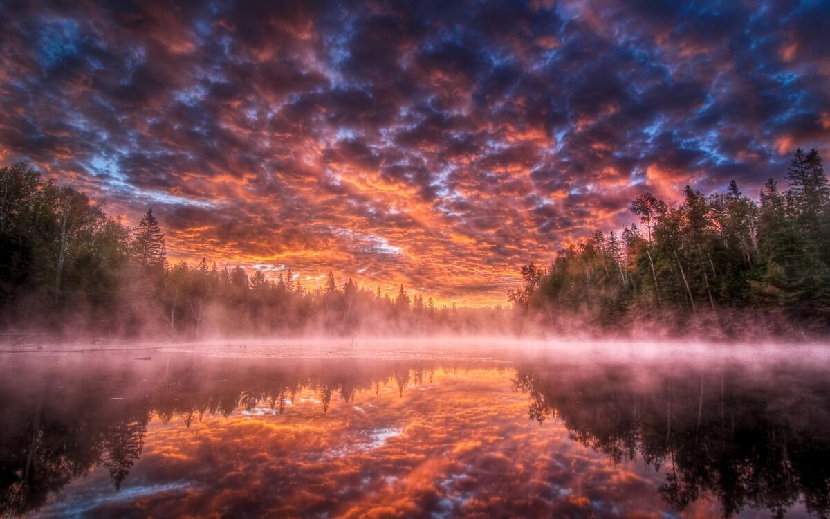 Красивый закат на озере с дымкой над водой
