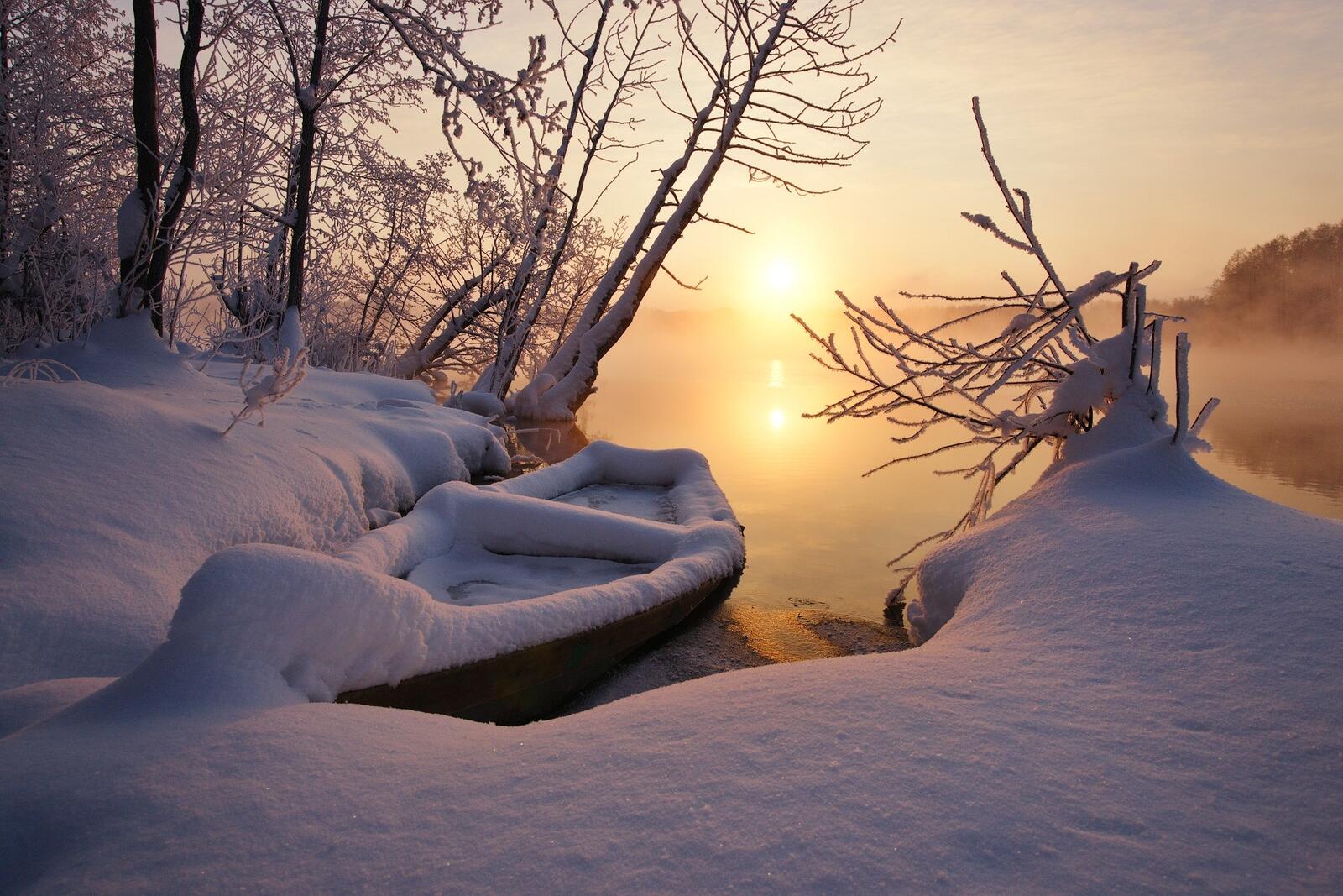 Бесплатное фото Лодка у берега озера  покрытая большим слоем снега