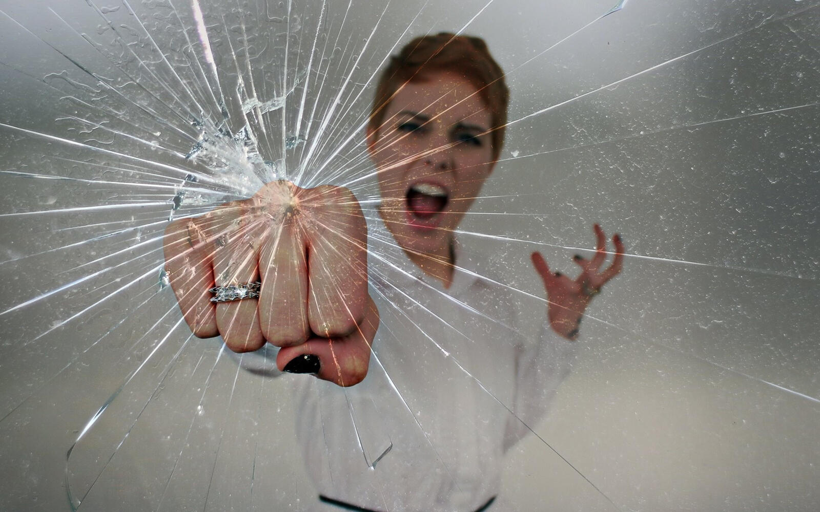 Free photo A girl breaks glass with her fist