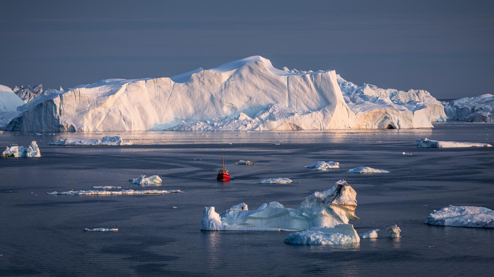 Free photo A floating ship near icebergs