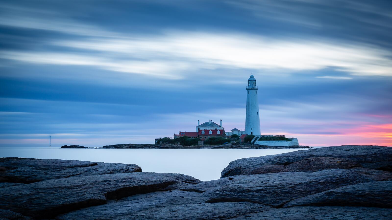 Free photo Lighthouse located on an island next to the ocean shore
