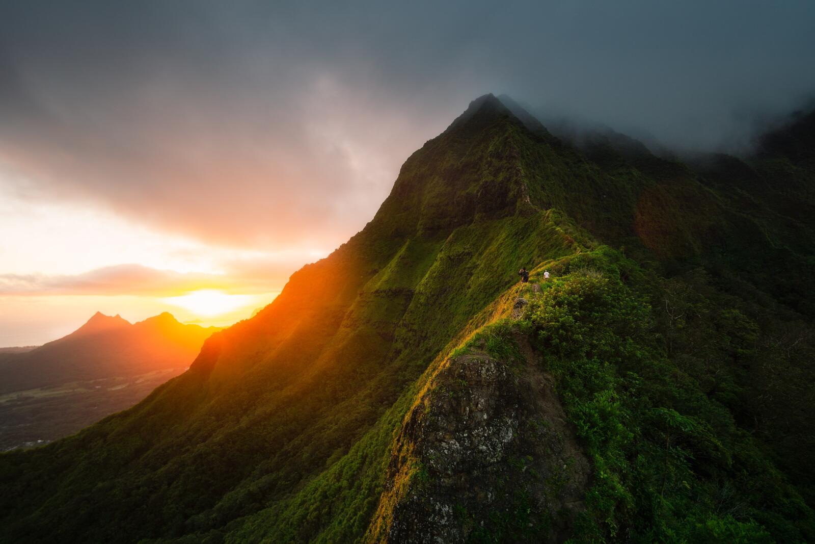 Бесплатное фото Путешественники поднимаются по хребту горы во время закат солнца