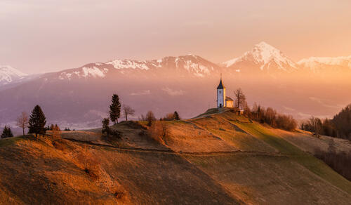 A church perched on a hill at sunset.