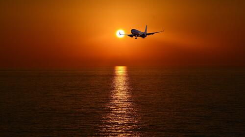 An airplane in the evening sky over the sea