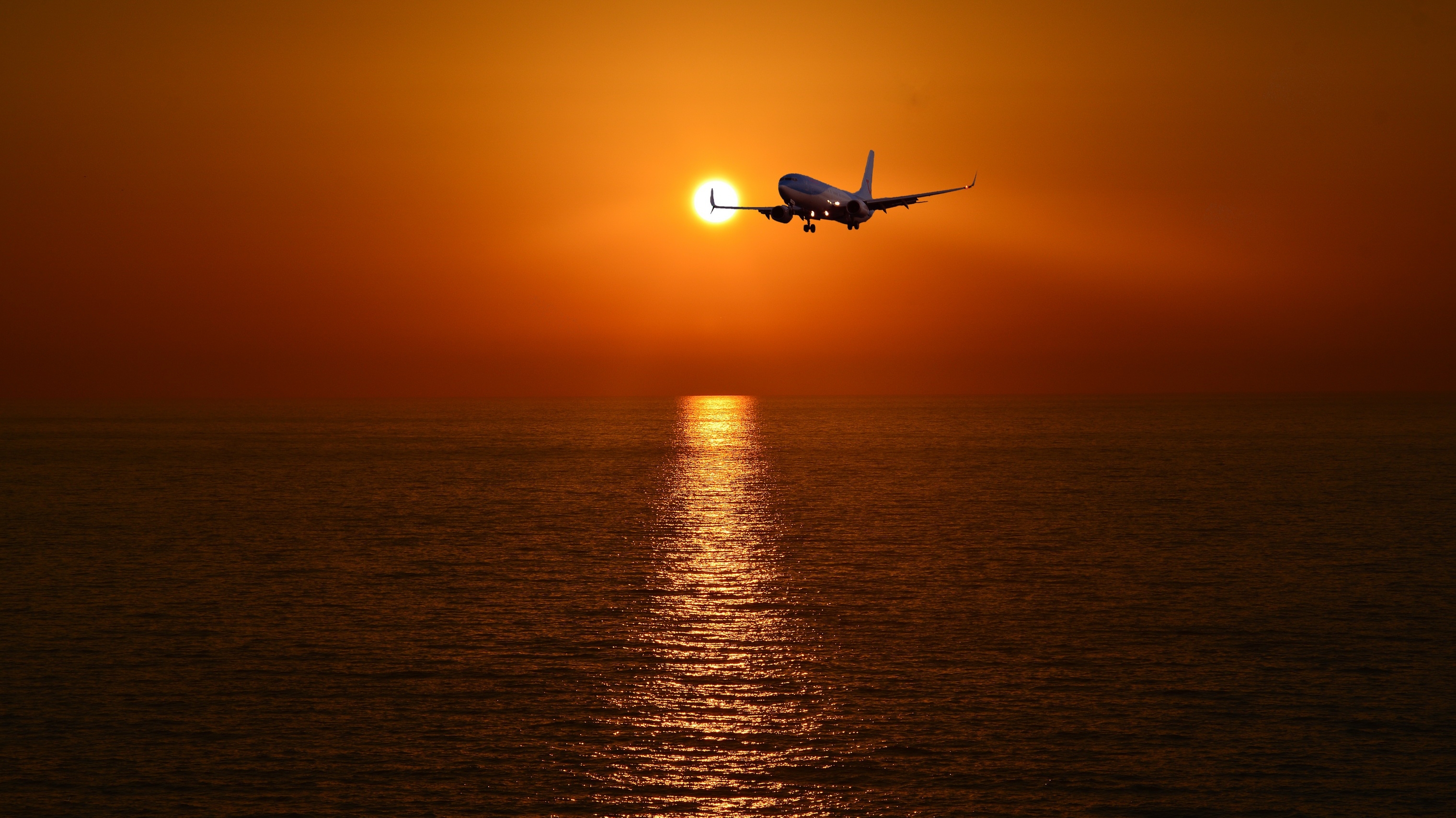 Free photo An airplane in the evening sky over the sea