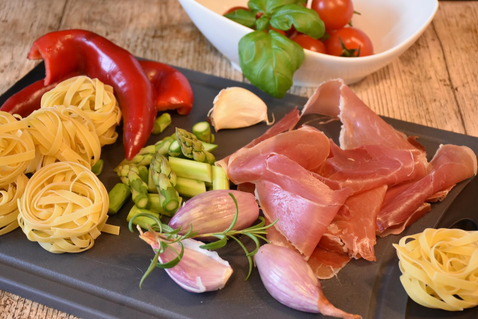 Бесплатное фото Сырое мясо с овощами на кухонном столе