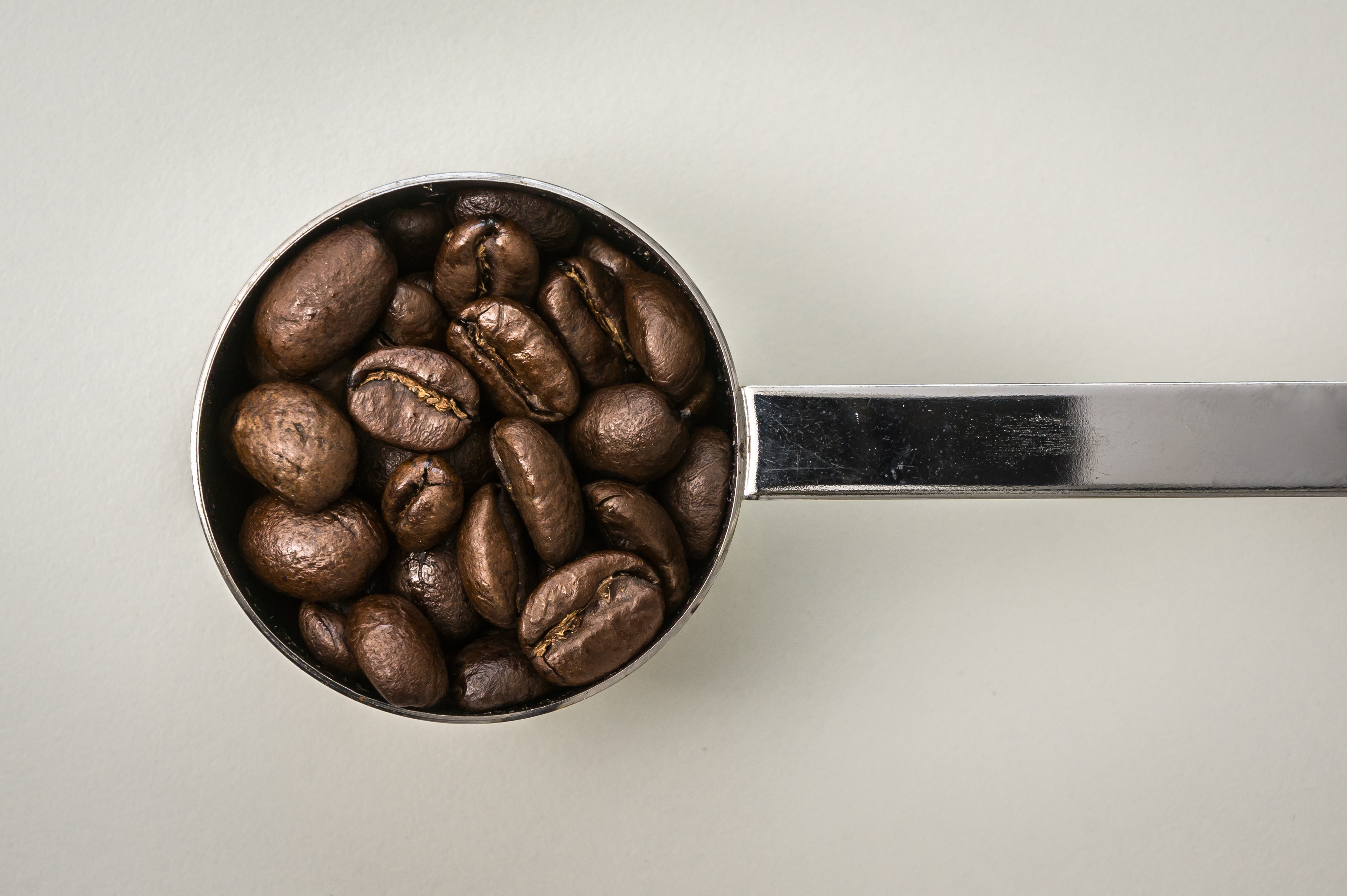 免费照片特制汤匙中的咖啡豆