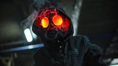 A man in a gas mask with red smoking eyes