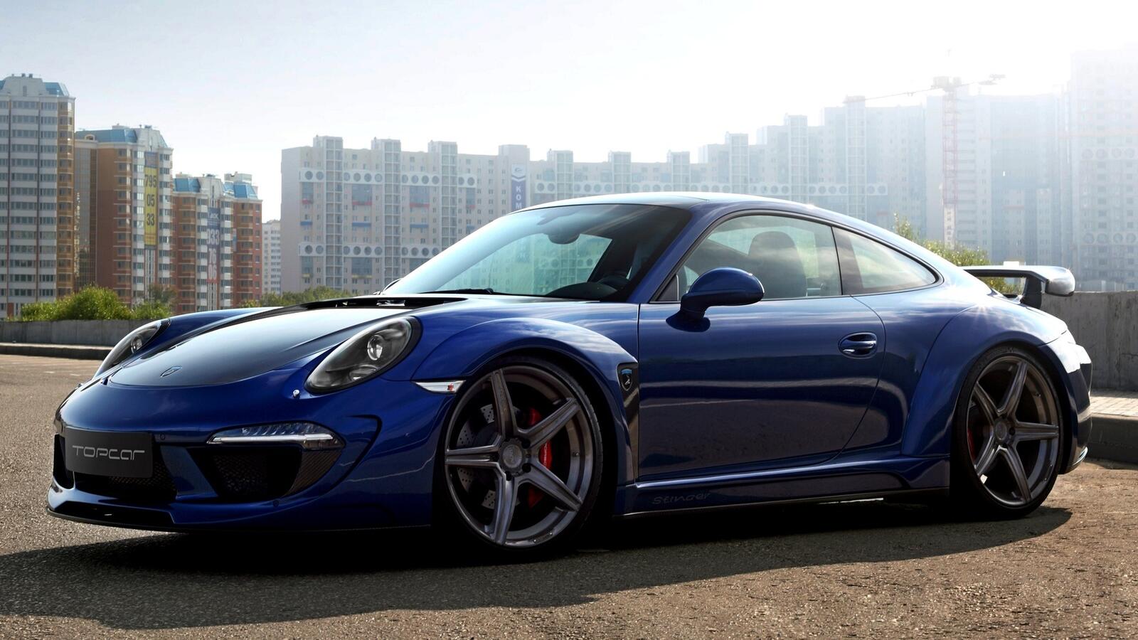Free photo Blue porsche 911 gt2 with the city as a backdrop.