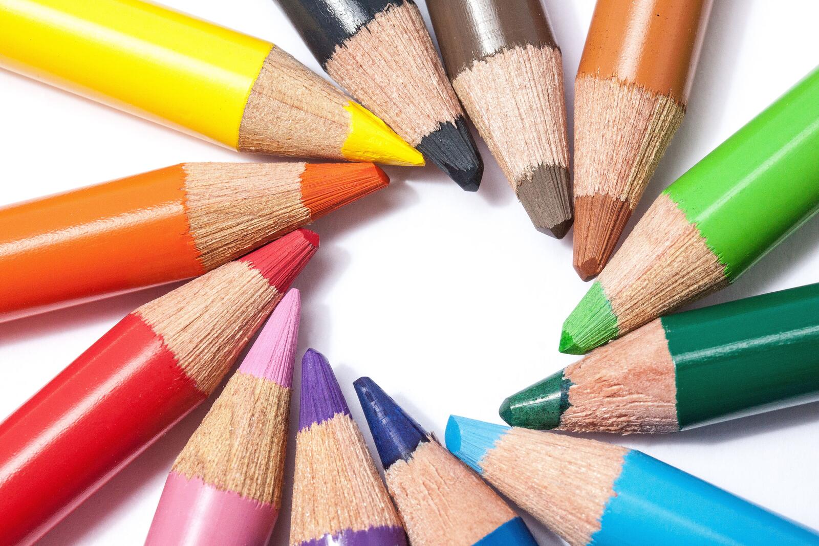 Free photo Colored pencils on a white background in the shape of a sun