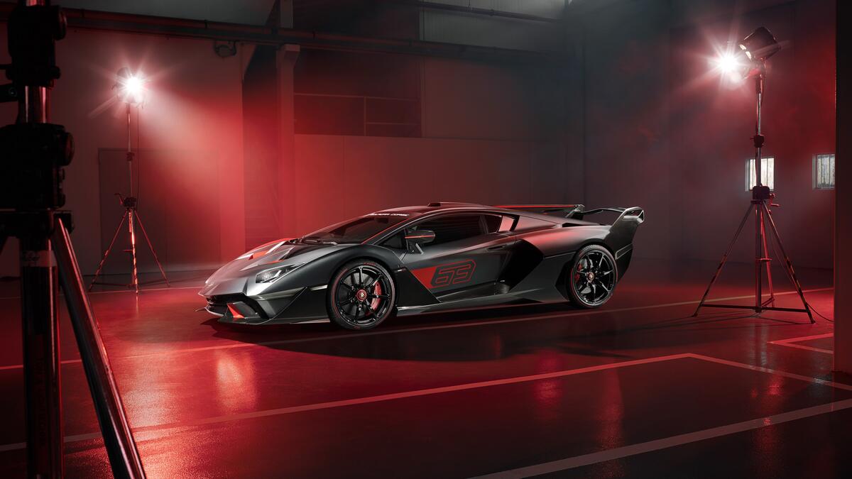 Lamborghini sc18 is standing indoors under red lights.