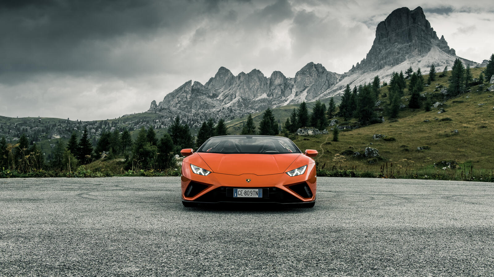 Free photo Orange Lamborghini Huracan Evo Spyder against a mountain backdrop