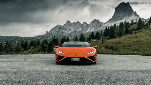 Оранжевая Lamborghini Huracan Evo Spyder на фоне гор