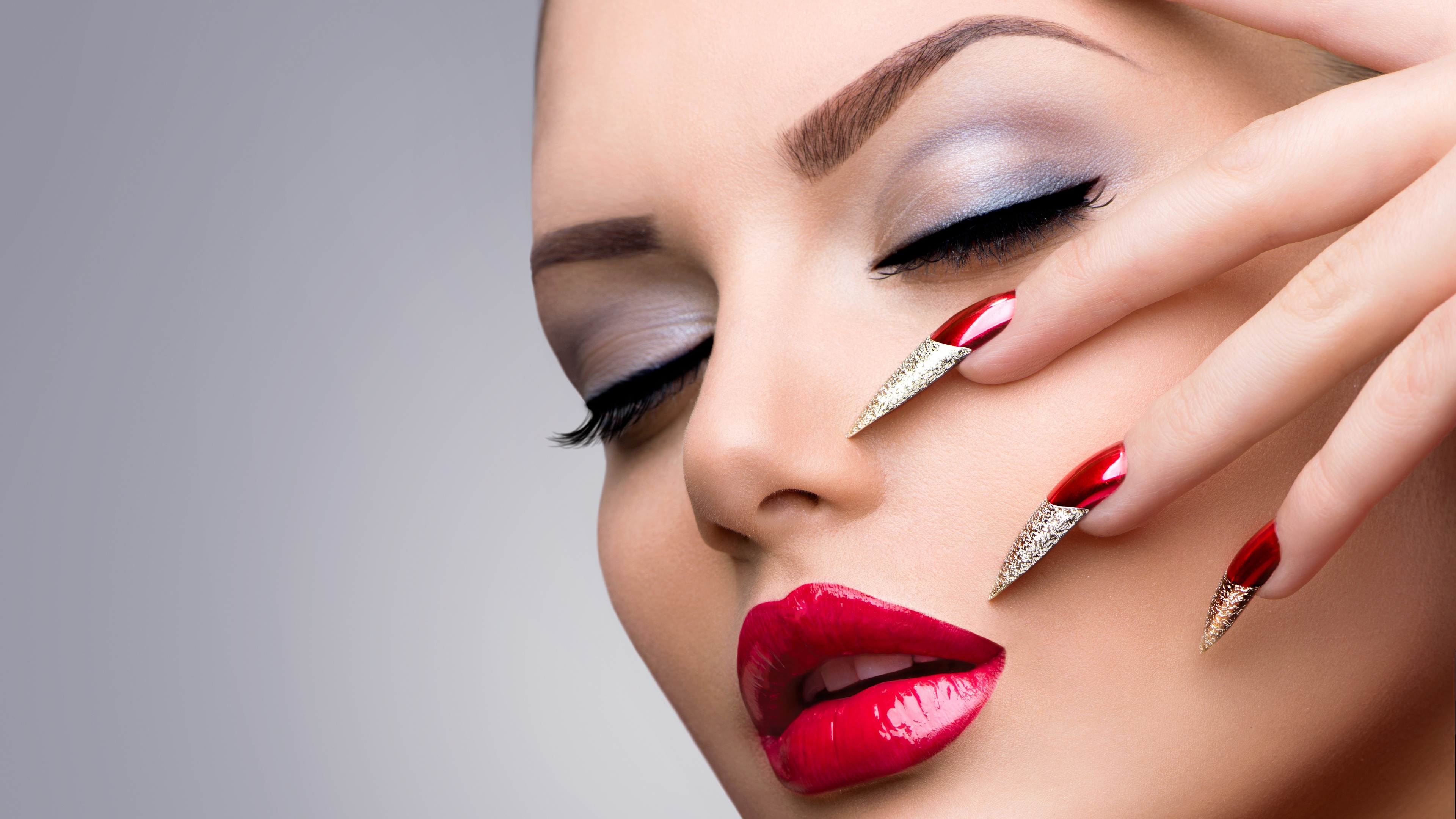 Model shows beautiful makeup and red manicure