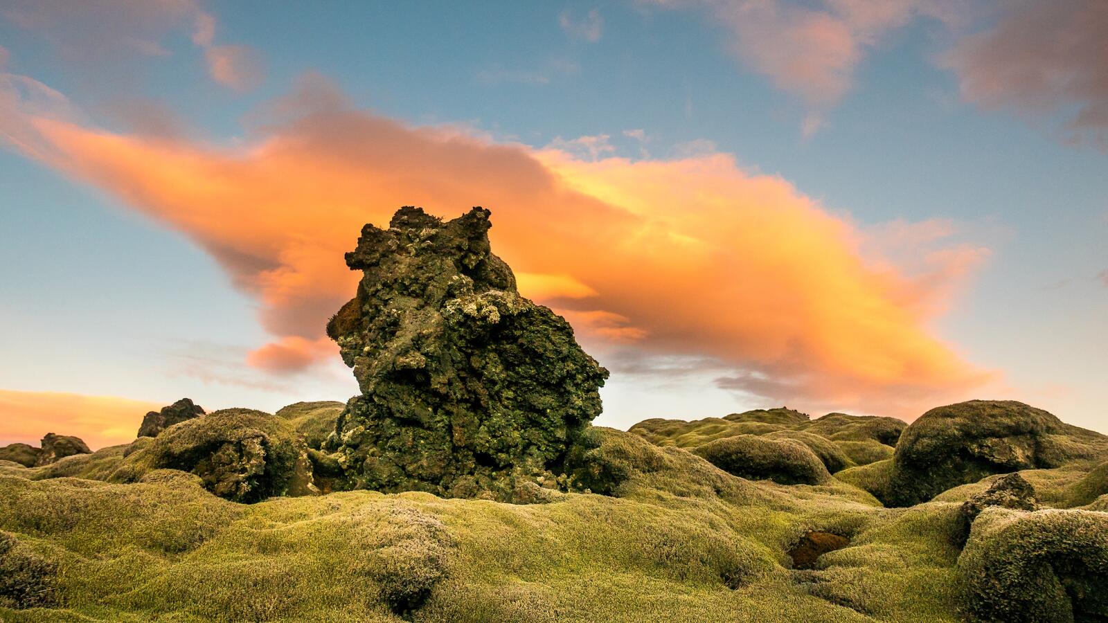 Бесплатное фото Большой острый камень лежит на зеленом мху