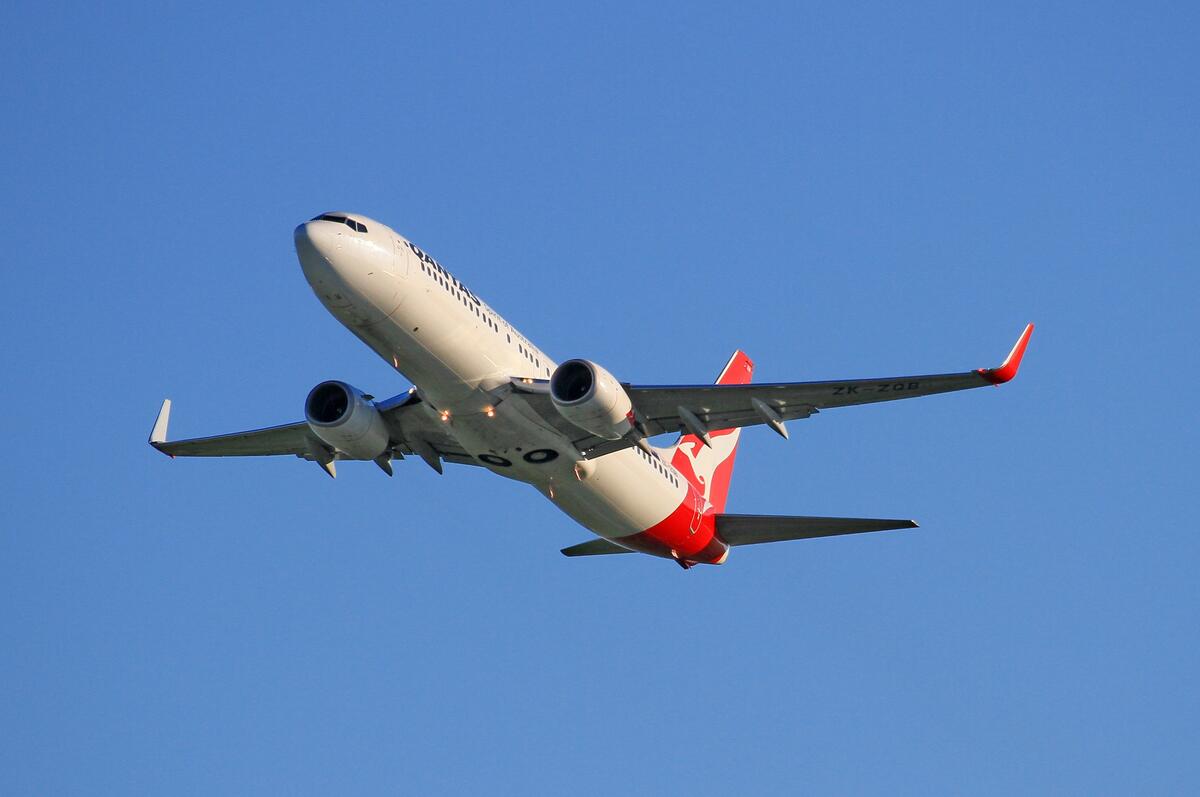 A passenger plane flies in a cloudless sky