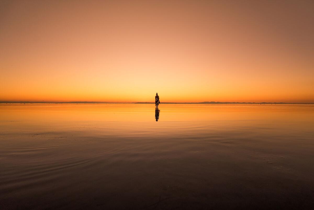 A silhouette of a man in the desert at sunset