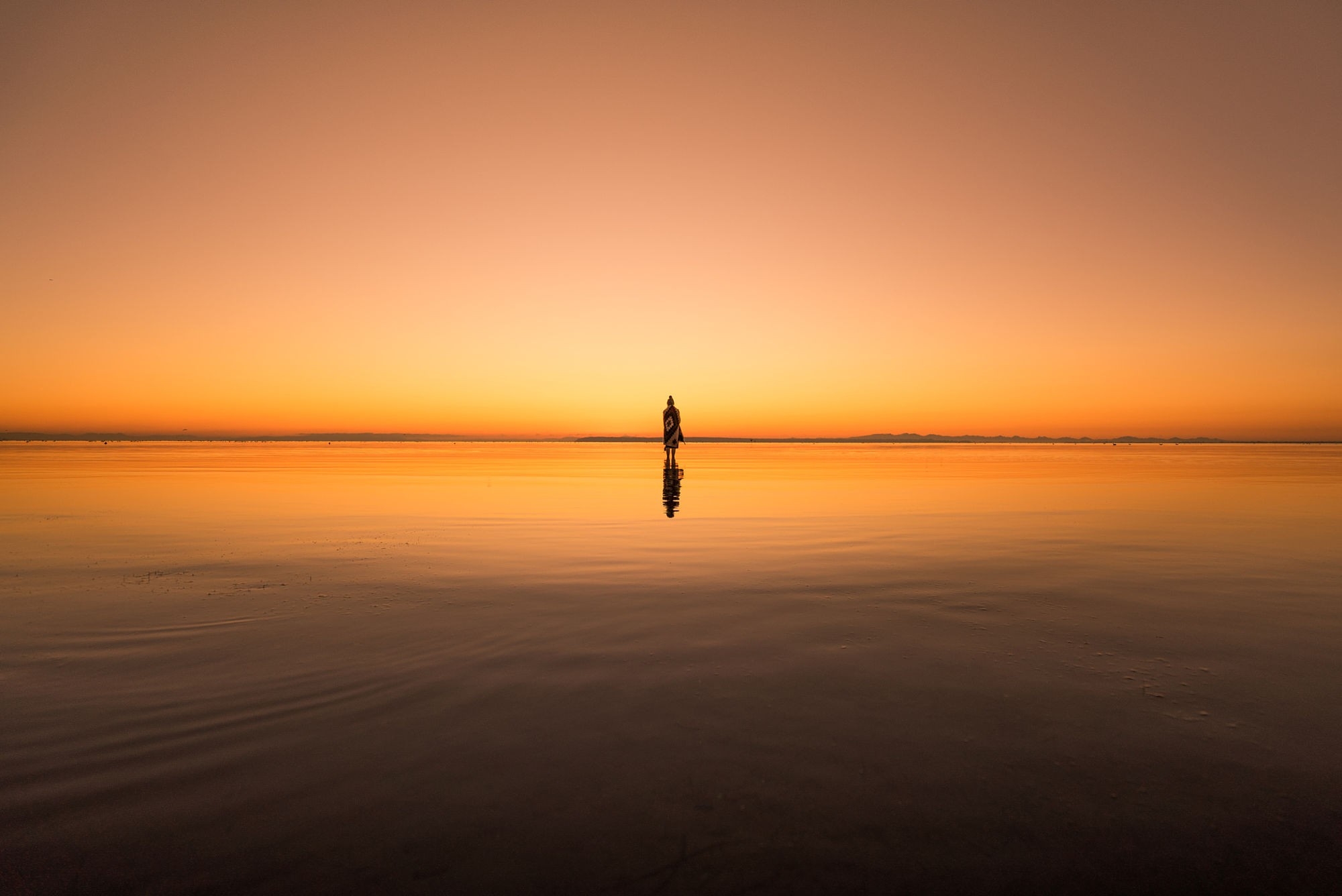 Бесплатное фото Силуэт человека на берегу при закате дня