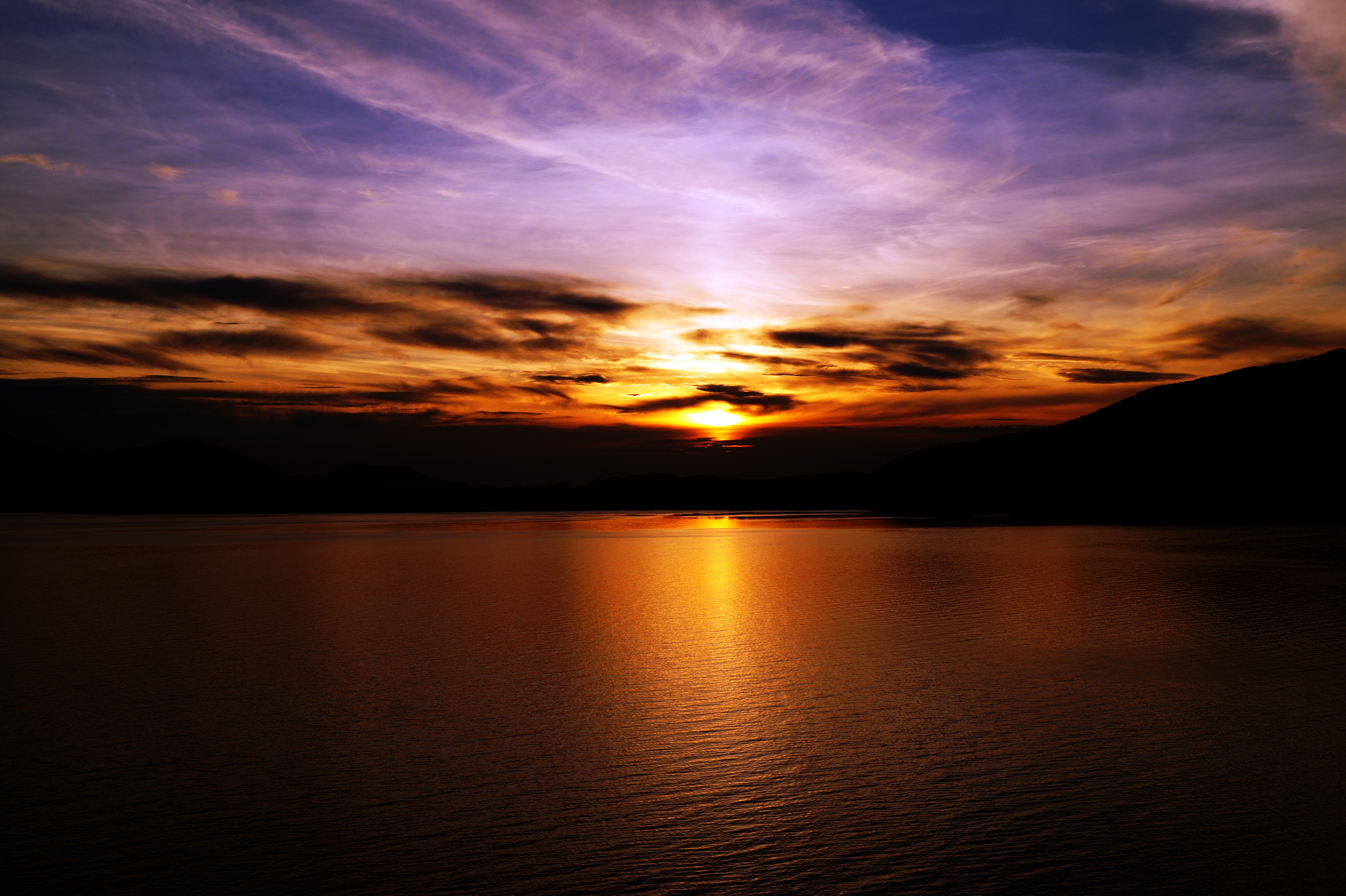 Бесплатное фото Солнце заходящие за тучи на озере